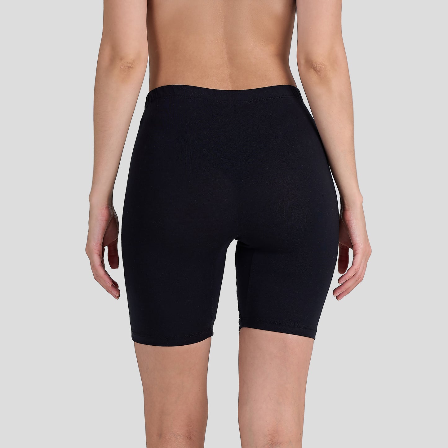 Person wearing a Dice black shorts on a plain background