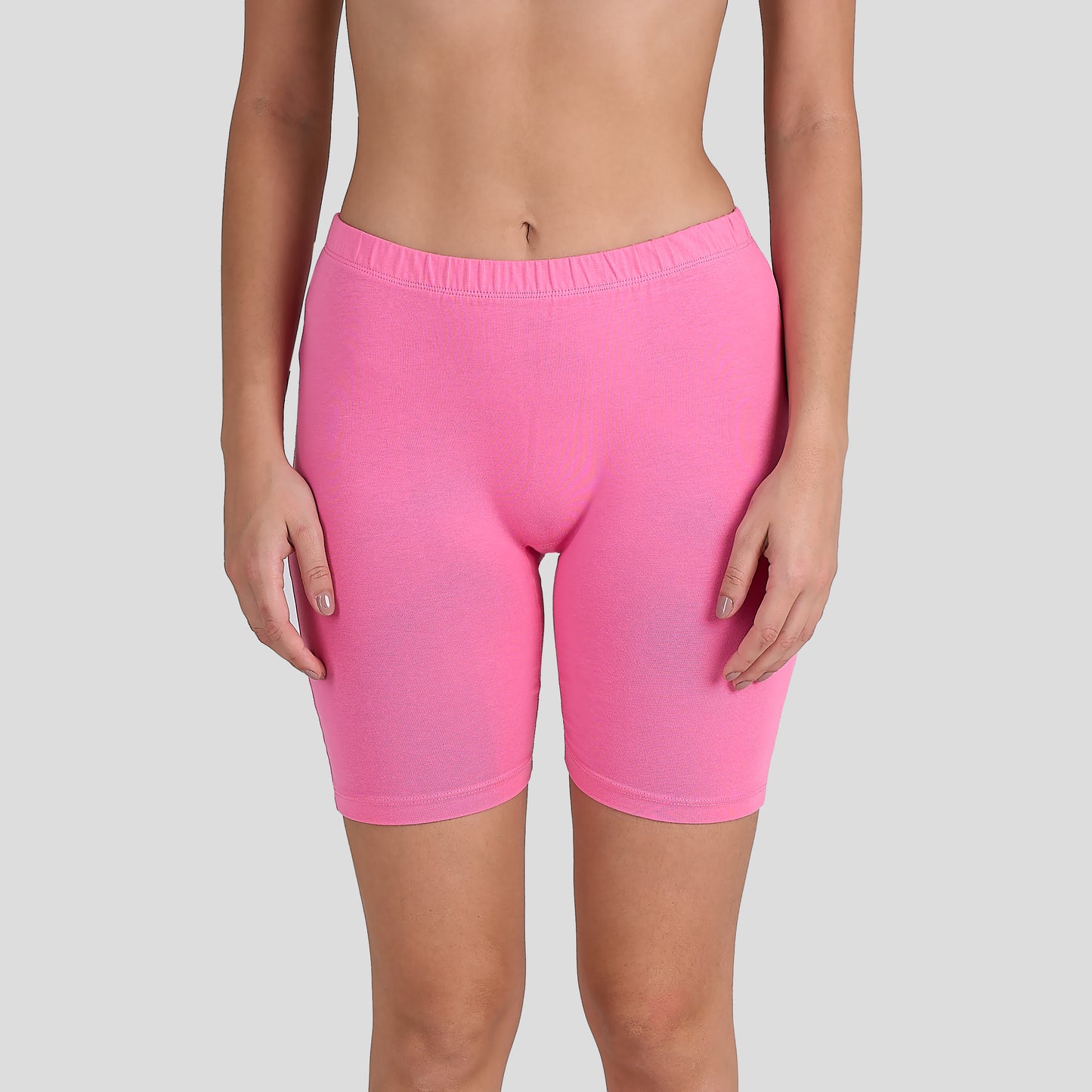Person wearing Dice bright pink shorts on a gray background