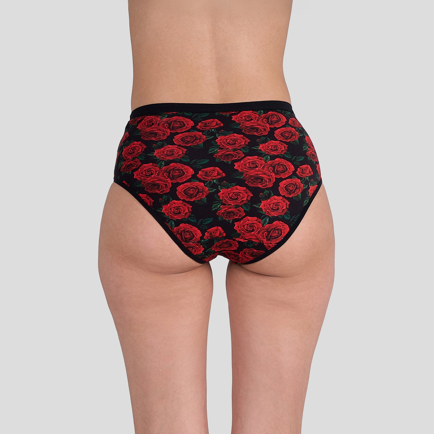 Dice Black underwear with red rose pattern worn by a person on a gray background