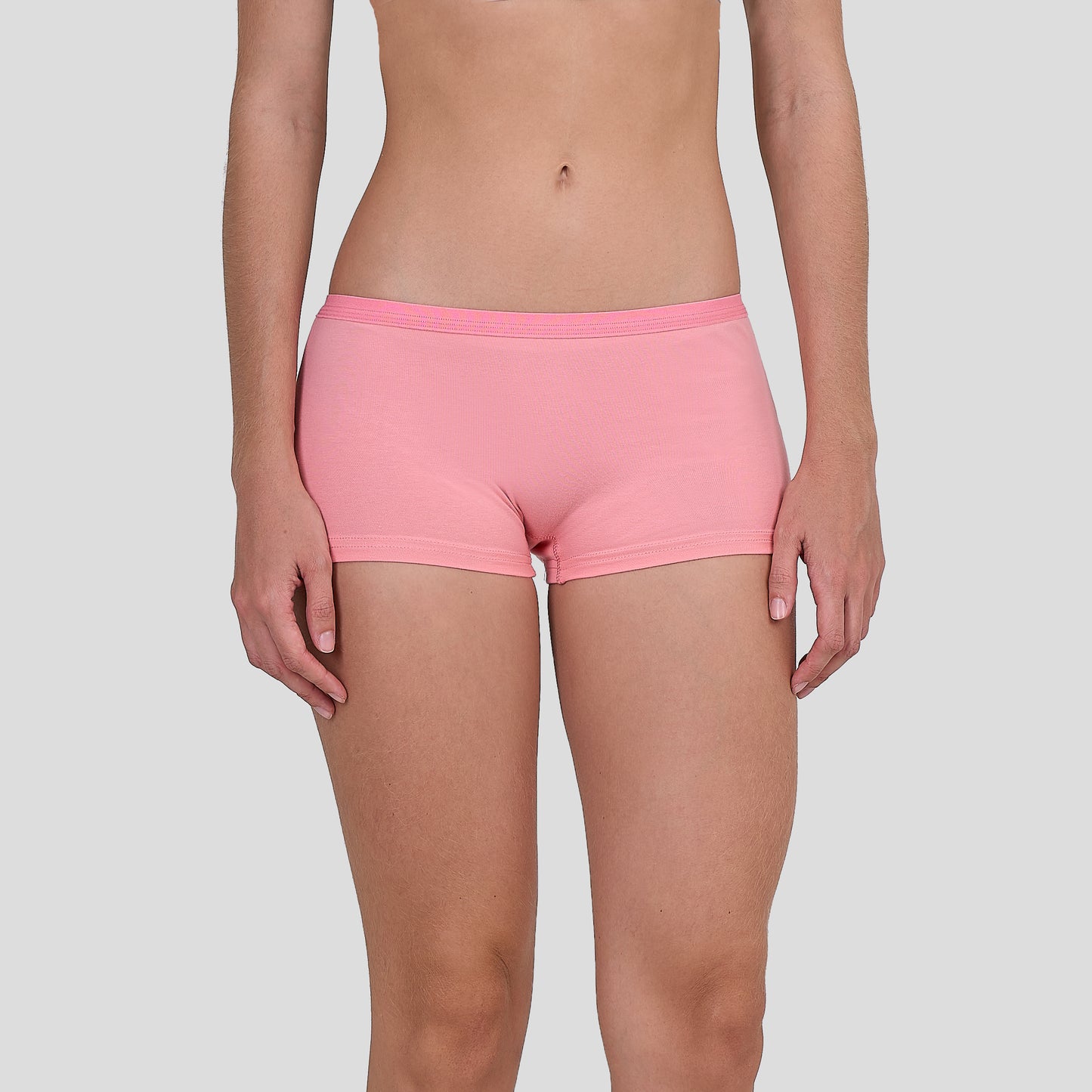 Person wearing a Dice pink shorts on a plain background