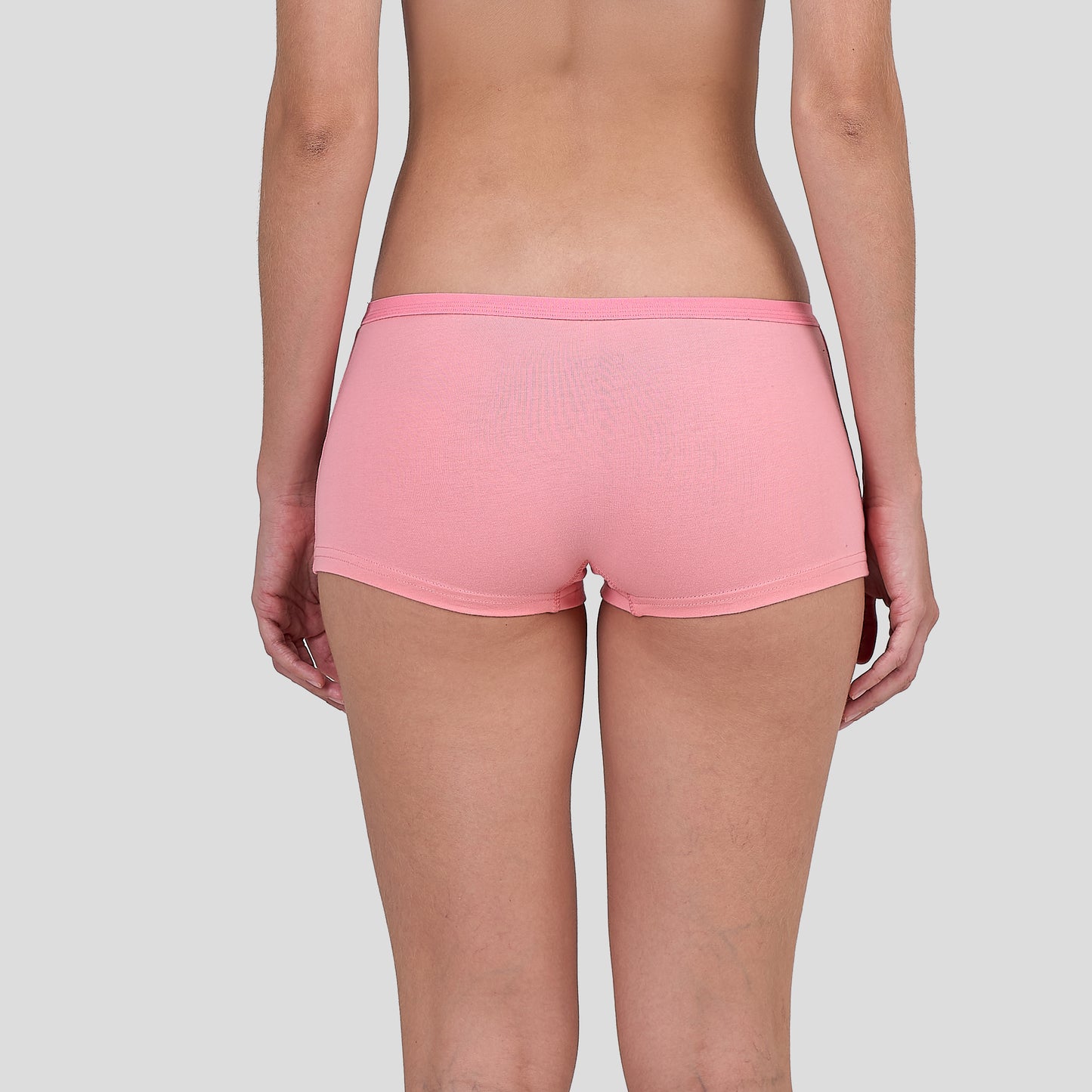 Person wearing a Dice pink shorts on a plain background