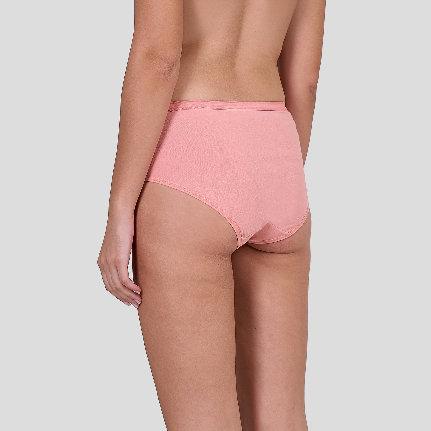 Person wearing a Dice pink high-waisted bikini bottom on a light gray background
