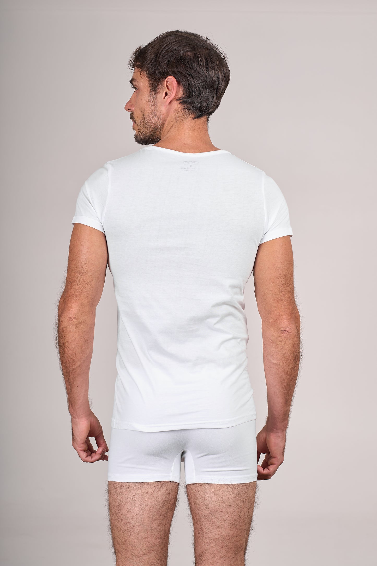 Man wearing Dice plain white t-shirt and underwear on a light gray background
