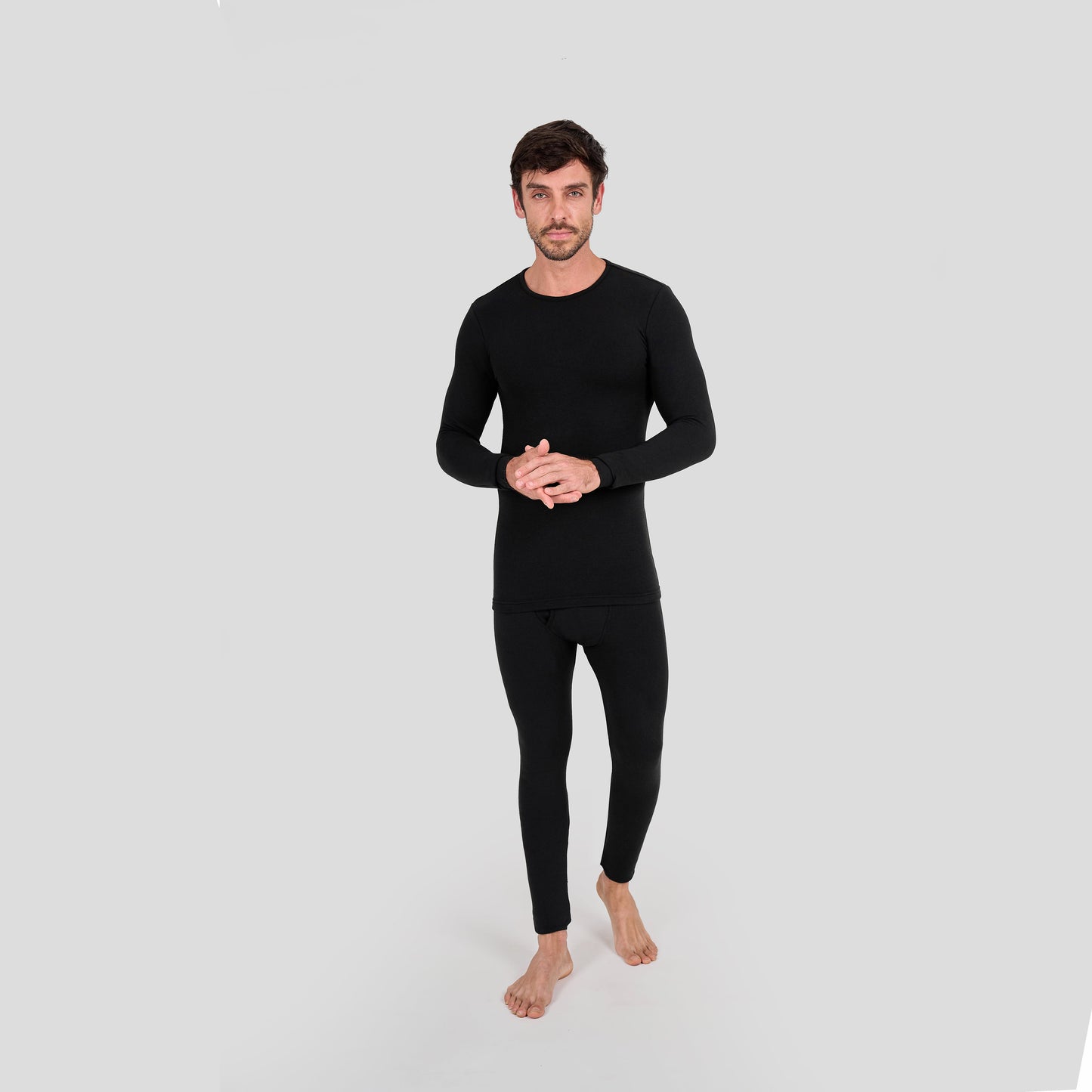 Man wearing a black thermal outfit on a light gray background