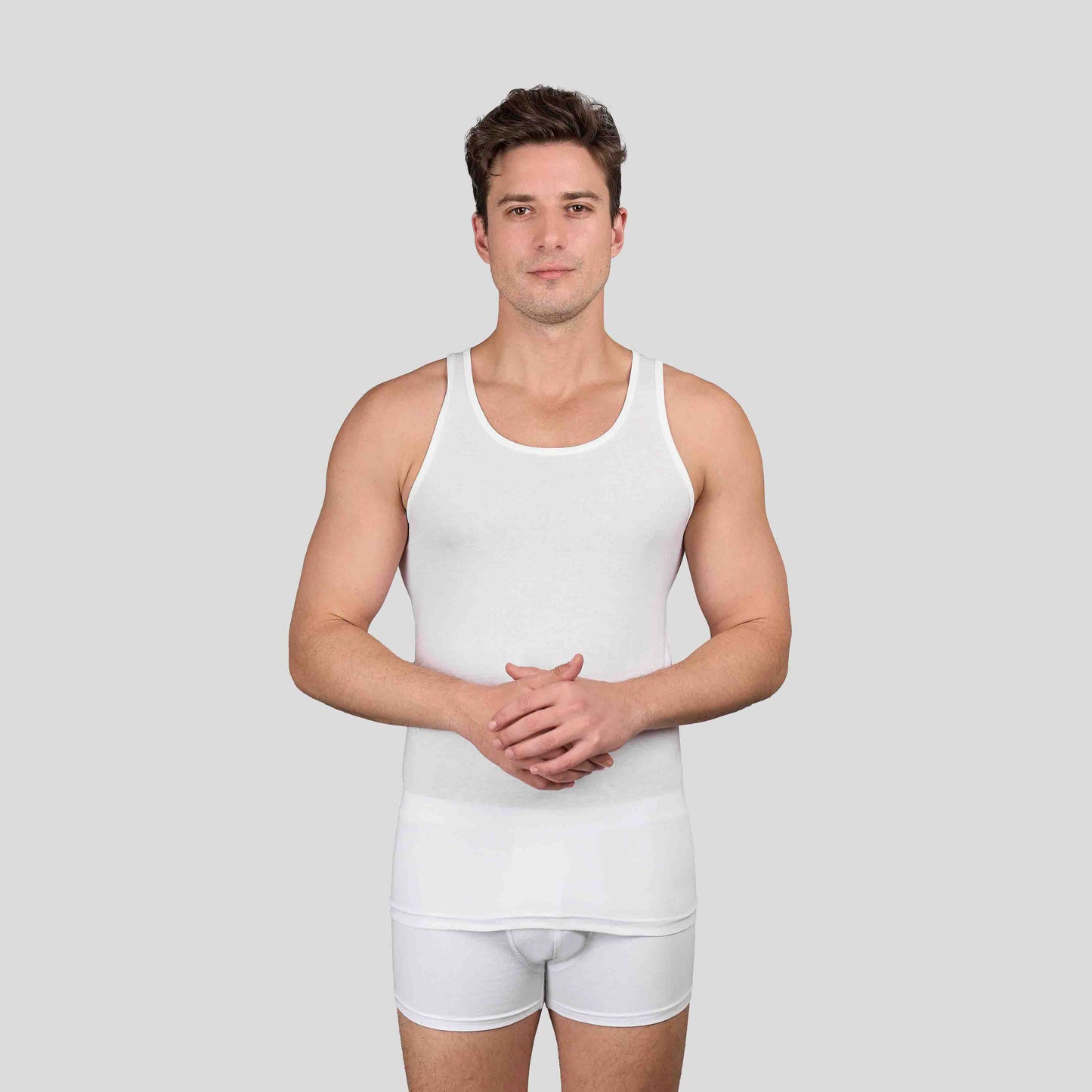 Man wearing Dice white tank top and shorts on a light gray background