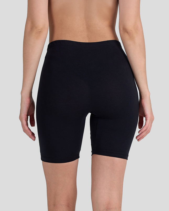 Person wearing a Dice black shorts on a plain background