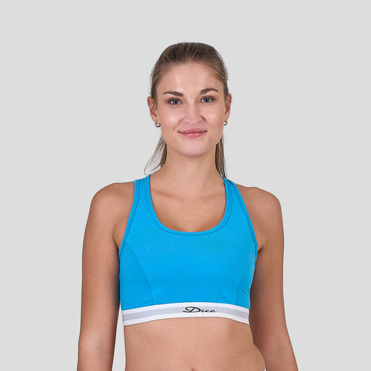 Woman wearing a Dice blue sports bra with a white brand logo on a light gray background