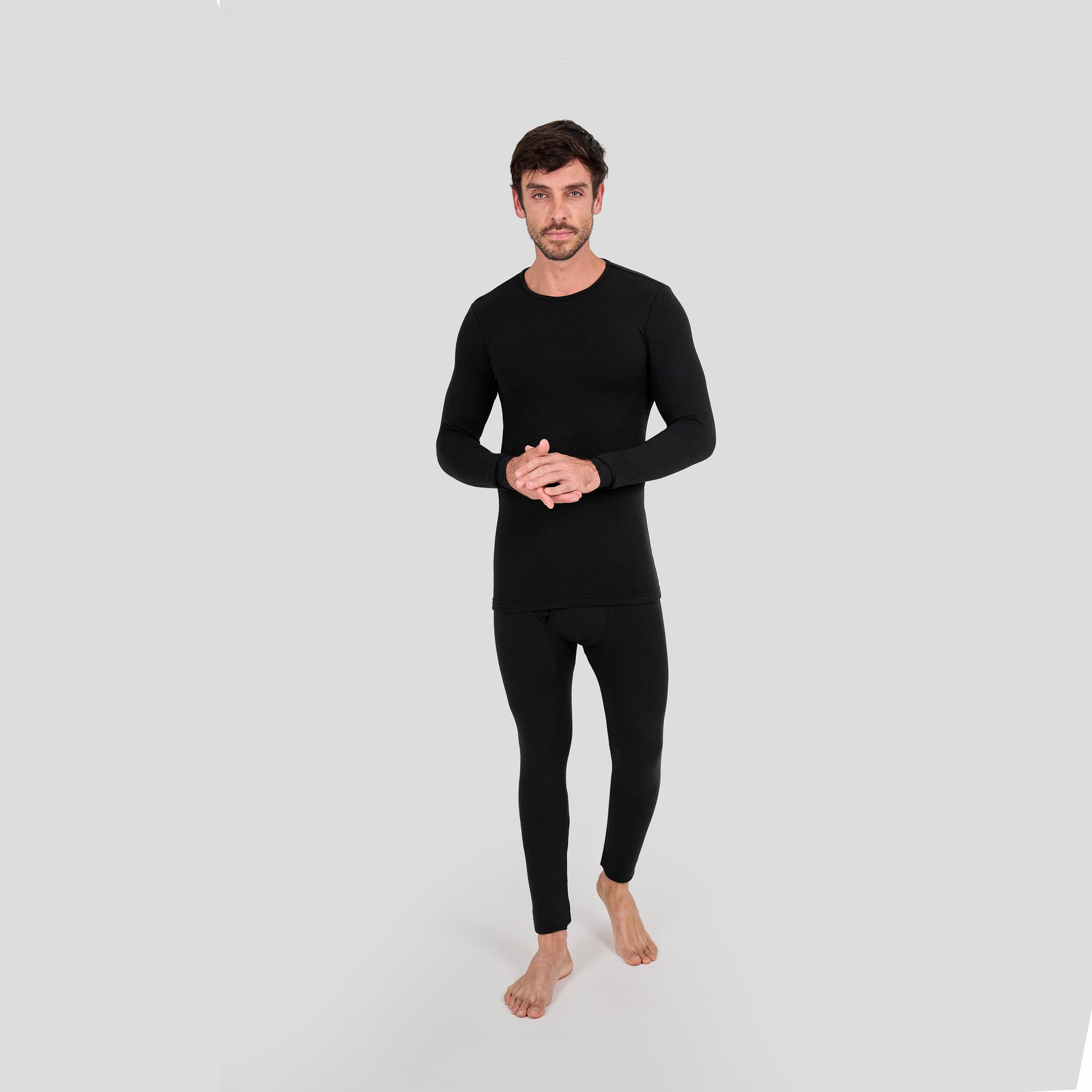 Man wearing a black thermal outfit on a light gray background