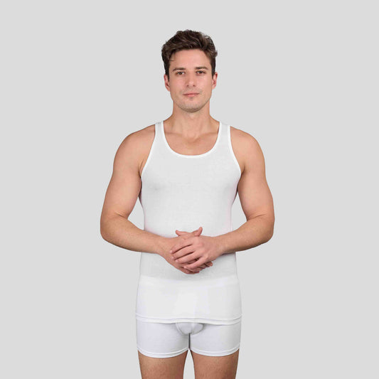 Man wearing Dice white tank top and shorts on a light gray background